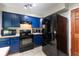 Spacious kitchen with blue cabinets, white countertops, stainless steel appliances, and tile flooring at 16533 E Baker Pl, Aurora, CO 80013