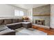 Comfortable living room with gray sofa, brick fireplace, hardwood floors, and a bright window at 16533 E Baker Pl, Aurora, CO 80013