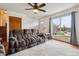 Comfortable living room featuring a plush sofa, ceiling fan and a large window with natural light and hardwood flooring at 16533 E Baker Pl, Aurora, CO 80013