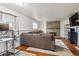 Well-lit living room features gray sectional sofa, hardwood floors, brick fireplace and views of the backyard at 16533 E Baker Pl, Aurora, CO 80013