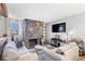 Comfortable living room featuring a stone fireplace, hardwood floors, and a neutral color palette at 13621 E Yale Ave # C, Aurora, CO 80014