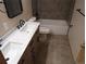 Modern bathroom featuring a double sink vanity, tiled floors, tub and updated fixtures at 9322 Jackson St, Thornton, CO 80229
