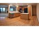 Kitchen featuring wood cabinets, stainless appliances, island, and wood floors with living room view at 9322 Jackson St, Thornton, CO 80229