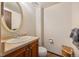 This powder room has a single vanity with a cream-colored countertop and a large oval mirror at 2742 S Xanadu Way, Aurora, CO 80014