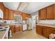 A vintage kitchen featuring wooden cabinets, white appliances, and a view from the window at 2742 S Xanadu Way, Aurora, CO 80014