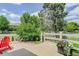 Charming back patio with red Adirondack chair, landscaping, and views of the surrounding neighborhood at 14075 Turnberry Ct, Broomfield, CO 80023