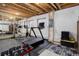 Unfinished basement gym area with exposed ceiling, featuring various fitness equipment and natural light at 14075 Turnberry Ct, Broomfield, CO 80023
