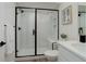 Modern bathroom featuring a glass shower, white subway tile, black hardware, and stylish vanity at 14075 Turnberry Ct, Broomfield, CO 80023