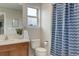 Neat bathroom with a sink vanity, toilet, and shower showcasing a decorative blue curtain at 14075 Turnberry Ct, Broomfield, CO 80023