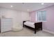 Charming bedroom with lilac walls, window and white trim, featuring a full-size bed and faux fur beanbag at 14075 Turnberry Ct, Broomfield, CO 80023