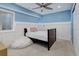 Cozy bedroom features a bed, wainscotting, blue paint and a fluffy beanbag chair, with natural light at 14075 Turnberry Ct, Broomfield, CO 80023