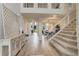 Bright foyer with wood floors, staircase, and decorative console table. Shows open floorplan to dining at 14075 Turnberry Ct, Broomfield, CO 80023