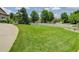 Expansive front yard with lush lawn, mature trees and white picket fence enclosing the property at 14075 Turnberry Ct, Broomfield, CO 80023