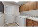 Bright laundry room equipped with modern washer and dryer, storage cabinets, and a utility sink at 14075 Turnberry Ct, Broomfield, CO 80023