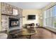 Bright living room with stone fireplace, hardwood floors, and plenty of sunlight at 6776 S Independence St, Littleton, CO 80128