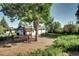 Large back yard with mature tree and a play set at 7704 Newland St, Arvada, CO 80003