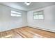 Bedroom with hardwood floors, two large windows, and neutral paint at 7704 Newland St, Arvada, CO 80003