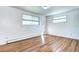 Bedroom with hardwood floors, two large windows, and neutral paint at 7704 Newland St, Arvada, CO 80003