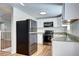 Updated kitchen with stainless steel appliances, granite countertops, and sleek black refrigerator at 7704 Newland St, Arvada, CO 80003