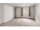 Unfinished basement with closet, window with green curtains, and white double doors at 5421 S Vivian St, Littleton, CO 80127