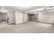 Spacious unfinished basement featuring neutral walls and carpet, with built in shelves for storage and easy access to stairs at 5421 S Vivian St, Littleton, CO 80127