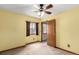 Yellow bedroom with window and wood door leading to the hallway at 5421 S Vivian St, Littleton, CO 80127