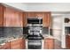 Bright kitchen with granite countertops, stainless steel appliances, and dark subway tile backsplash at 5421 S Vivian St, Littleton, CO 80127