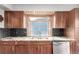 Close-up of kitchen with stainless steel sink, granite countertops, and dark wood cabinetry at 5421 S Vivian St, Littleton, CO 80127
