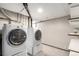 Laundry area featuring modern washer and dryer appliances, shelving, and storage space at 5421 S Vivian St, Littleton, CO 80127