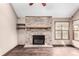 Living room featuring a brick fireplace with hearth, wood flooring and a window with a view to the backyard at 5421 S Vivian St, Littleton, CO 80127