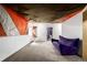 Finished basement with a vibrant purple couch, art decorations, and new carpet at 17706 Cherokee St, Broomfield, CO 80023