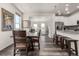Open-concept dining room featuring a dark wood table and chairs adjacent to the kitchen with light cabinets at 17706 Cherokee St, Broomfield, CO 80023