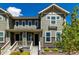 Charming townhome showcasing a covered porch, complemented by verdant landscaping and detailed architectural trim at 17706 Cherokee St, Broomfield, CO 80023