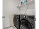 Modern laundry room featuring front loading washer and dryer, with convenient overhead shelving at 17706 Cherokee St, Broomfield, CO 80023