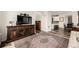Living room features a large, decorative area rug and a dark wood console with a flat screen television at 17706 Cherokee St, Broomfield, CO 80023