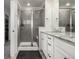 Modern main bathroom featuring a glass-enclosed shower, double vanity with granite countertops, and white cabinets at 17706 Cherokee St, Broomfield, CO 80023