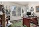 Home office with a dark wood desk, green rug, and natural light from the windows at 17706 Cherokee St, Broomfield, CO 80023