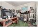 Cluttered office space with a large wooden desk, multiple monitors, and eclectic decor at 17706 Cherokee St, Broomfield, CO 80023