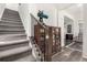 Carpeted staircase with a dark wood banister and display case, leading to the upper level of the home at 17706 Cherokee St, Broomfield, CO 80023