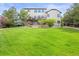 Landscaped backyard with green lawn, patio, mature trees, and a fence line at 22485 Laurel Oak Dr, Parker, CO 80138
