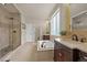 Bright bathroom featuring a soaking tub, a walk-in shower, and double vanities with modern fixtures at 22485 Laurel Oak Dr, Parker, CO 80138