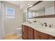 Bathroom with dual sinks, white marble countertop, wood cabinets, and decorative mirror at 22485 Laurel Oak Dr, Parker, CO 80138