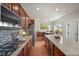 Modern kitchen with stainless steel appliances, wood cabinets, and stone countertops at 22485 Laurel Oak Dr, Parker, CO 80138