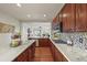 A modern, spacious kitchen boasts granite countertops and wood cabinets with seamless flow to the Gathering room at 22485 Laurel Oak Dr, Parker, CO 80138