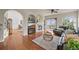 Open-concept living room with fireplace, hardwood floors, archways, and a view to the outside at 22485 Laurel Oak Dr, Parker, CO 80138