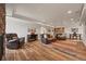 Open-concept living room featuring leather seating and luxury vinyl plank flooring, plus a partial view of the kitchen at 22485 Laurel Oak Dr, Parker, CO 80138
