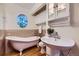 Bright bathroom features a clawfoot tub, pedestal sink, modern fixtures and wood flooring at 5857 S Logan Ct, Centennial, CO 80121