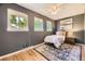Cozy bedroom with hardwood floors, gray walls and lots of natural light from two large windows at 5857 S Logan Ct, Centennial, CO 80121