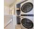Conveniently located laundry area with stacked washer and dryer units, shelving, and ample lighting at 5857 S Logan Ct, Centennial, CO 80121