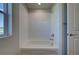 Bright bathroom featuring a bathtub with white tile surround and a window providing natural light at 16858 Greyhawk Dr, Monument, CO 80132
